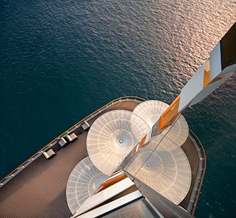 Aerial view of a cruise ship deck with stylish sunshades and loungers over the shimmering sea | MSC Cruises Aerial view of a cruise ship deck with stylish sunshades and loungers over the shimmering sea | MSC Cruises