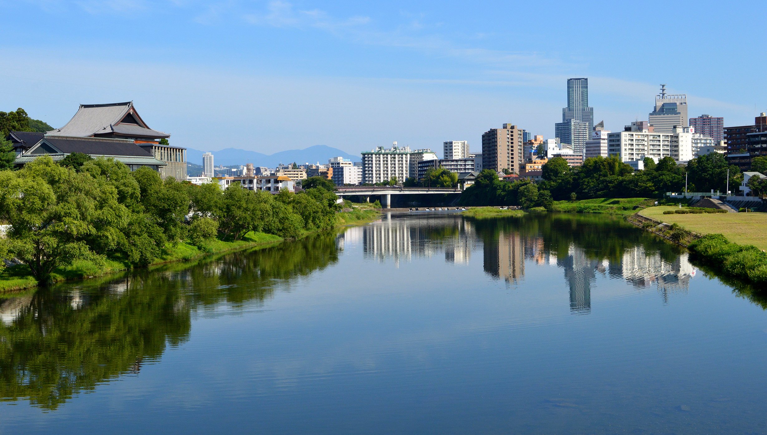 A serene river view with traditional Japanese architecture and modern cityscape | MSC Cruises A serene river view with traditional Japanese architecture and modern cityscape | MSC Cruises