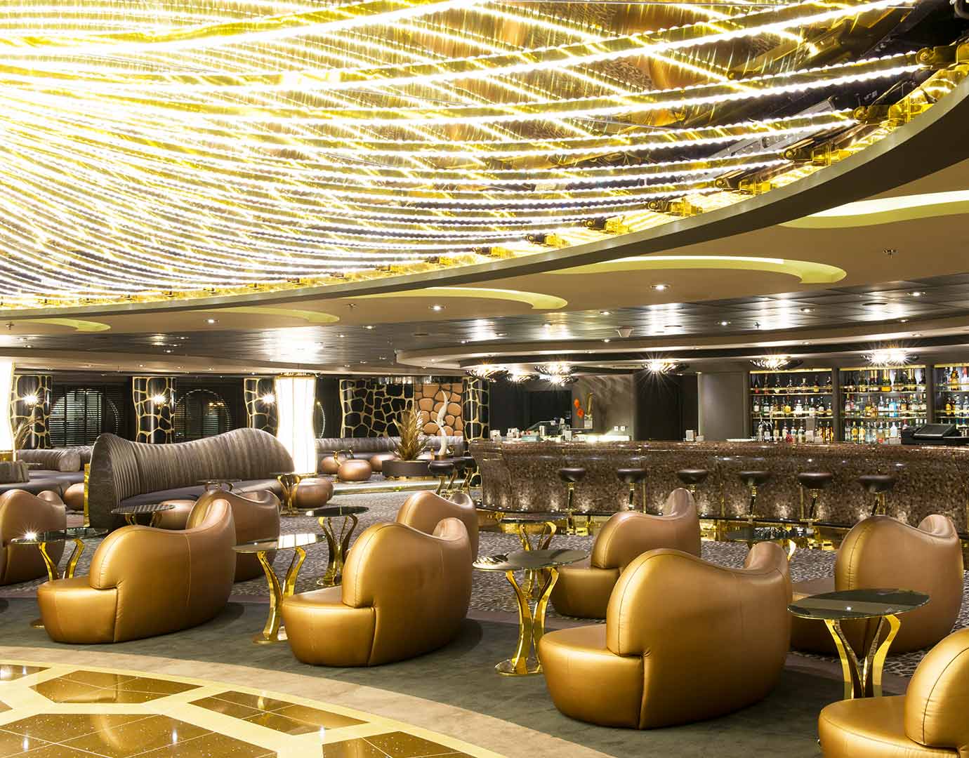 Luxurious cruise ship lounge with golden decor and modern seating | MSC Cruises Luxurious cruise ship lounge with golden decor and modern seating | MSC Cruises