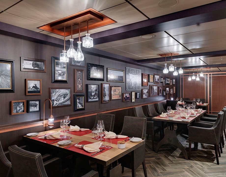 Elegant onboard restaurant with modern decor and framed art on the walls | MSC Cruises Elegant onboard restaurant with modern decor and framed art on the walls | MSC Cruises