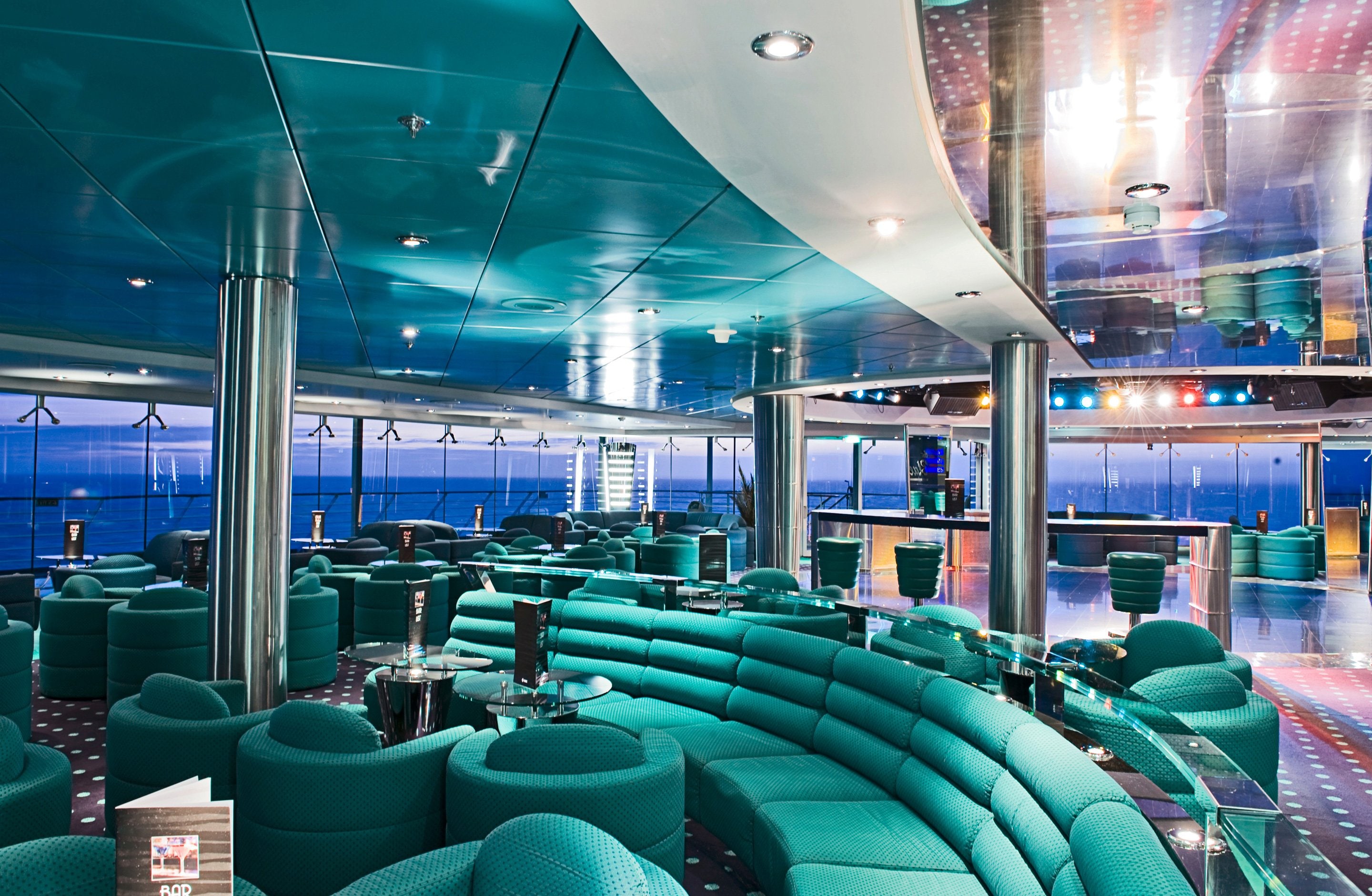 Elegant lounge with panoramic ocean views and modern seating on an MSC cruise ship | MSC Cruises Elegant lounge with panoramic ocean views and modern seating on an MSC cruise ship | MSC Cruises