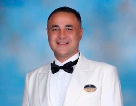 A crew member in a white uniform with an MSC Cruises badge | MSC Cruises A crew member in a white uniform with an MSC Cruises badge | MSC Cruises